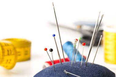 Dikiş araçları ile arkaplanda sewign iğneleri koleksiyonu kapalı beyaz arkaplan seçici odaklı