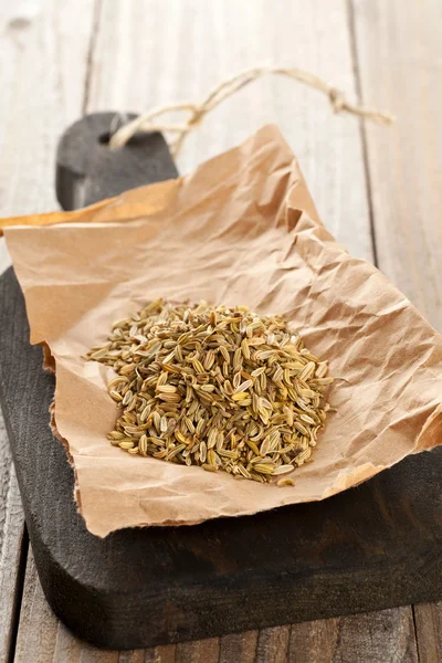 Heap of fennel seeds on kitchen board — Stock Photo, Image