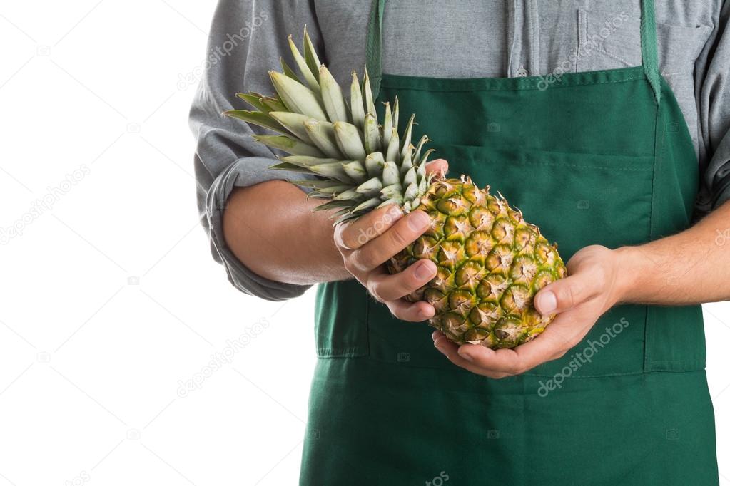 Farmer holding whole fresh pineapple fruit