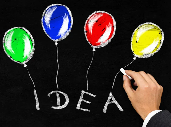 実業家で黒板に書かれた風船を持つ ' アイデア ' — ストック写真