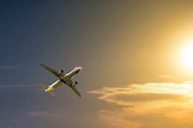 Güzel bir gün batımı doğru uçan bir uçak