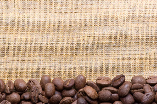 Corner decoration of coffee beans on sacking material — Stock Photo, Image