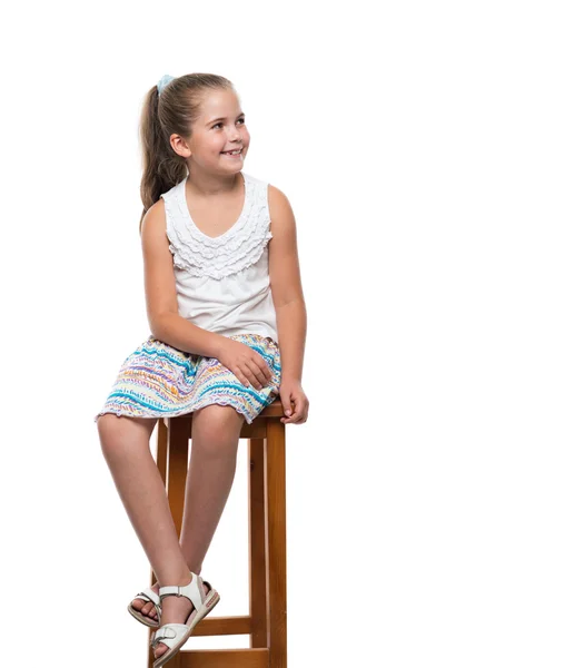Kis lány ül a széken — Stock Fotó