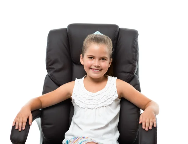 Petite fille assise dans un grand fauteuil Photo De Stock
