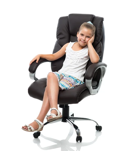 Petite fille assise dans un grand fauteuil de bureau Images De Stock Libres De Droits