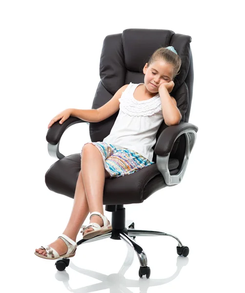 Petite fille assise dans un grand fauteuil de bureau Photo De Stock