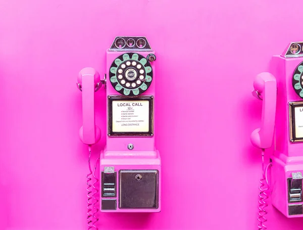 Pembe duvarda pembe bir paralı telefon.