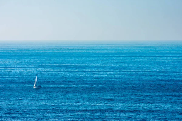 a sailboat sailing in the middle of the ocean