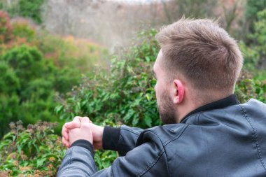 Parkta arkadan genç bir adamın yakın portresi.