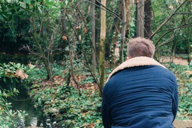 Arkadan parka bakan genç bir adam.