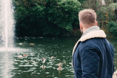 Gölün kenarında sakallı, çekici, genç bir sarışın.