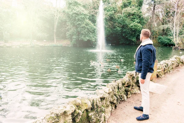 Gölün kenarında sakallı, çekici, genç bir sarışın.