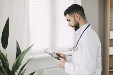 Dijital tablet üzerinde çalışan genç bir doktor. Tıbbi konsept