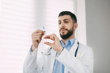 Doktor enjeksiyon için bir şırınga hazırlar. Tıbbi konsept