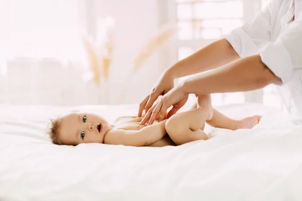 Mamma masserar varsamt magen, tar hand om honom och hans hälsa. — Stockfoto