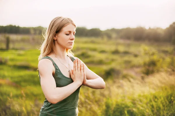 Una joven medita después de una clase de yoga en la naturaleza. El concepto de salud mental y estilo de vida saludable — Foto de Stock