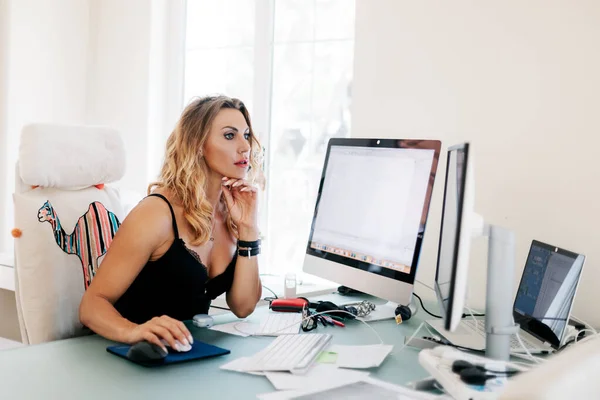 Uma jovem elegante a trabalhar num computador no escritório. Negócios, mulher de negócios, local de trabalho — Fotografia de Stock