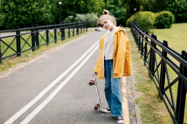 도시 공원에서 스케이트보드타는 법을 배우는 행복 한 십 대 소녀. — 스톡 사진