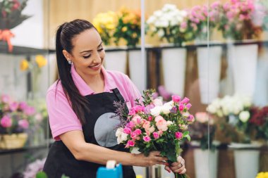 Çiçekçide bir çiçekçi kız tatil için bir buket yapar. Aile işi, güzel çiçek aranjmanı..