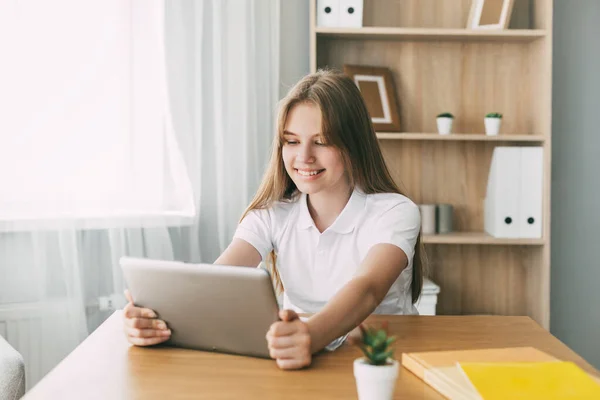 The girl studies at home with a digital tablet and does homework at school. Distance learning online education — Stock Photo, Image