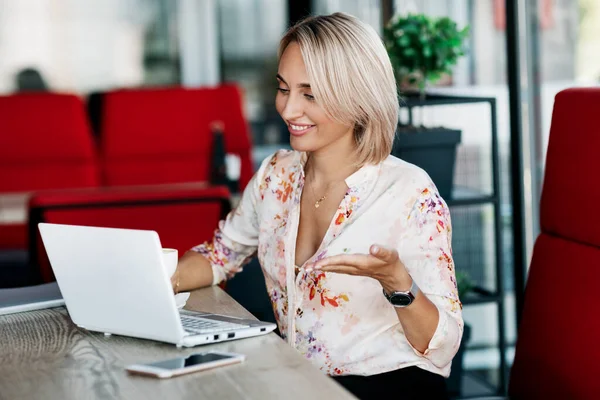 Retrato de uma jovem mulher de negócios trabalhando em um laptop, se comunicando com colegas on-line. Freelance, negócios, negócios online — Fotografia de Stock