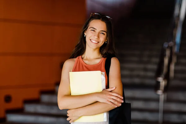 Retrato de una chica sonriente con una carpeta en las manos — Foto de Stock