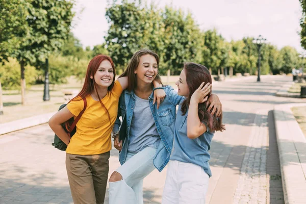 Tři veselé puberťačky přijíždějící ze školy. Koncept odborné přípravy a vzdělávání — Stock fotografie
