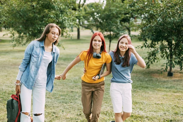 Tři puberťačky jdou po škole do parku. Koncept odborné přípravy a vzdělávání. Zpátky do školy — Stock fotografie