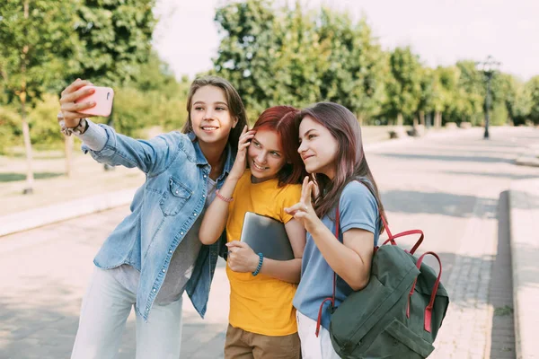Tři půvabní přátelé si berou selfie s telefonem na cestě do školy. Koncept přátelství. Vzdělání, odborná příprava, návrat do školy — Stock fotografie