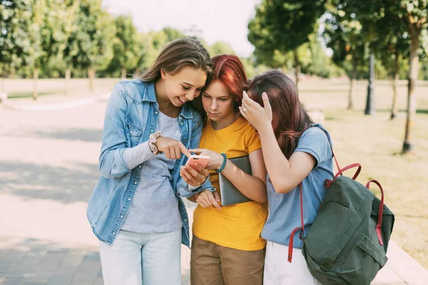 Trzech czarujących przyjaciół robi sobie selfie telefonem w drodze do szkoły. Koncepcja przyjaźni. Edukacja, szkolenia, powrót do szkoły — Zdjęcie stockowe