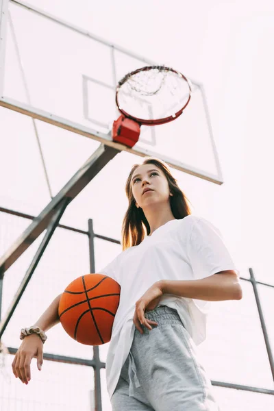 Retrato de uma menina jogador de basquete pensativo com uma bola em suas mãos. Basquete, esportes, estilo de vida saudável — Fotografia de Stock