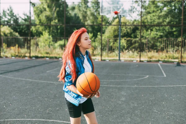 Seorang pemain basket muda berlatih di lapangan basket terbuka, seorang gadis remaja bermain basket. Bola basket, olahraga — Stok Foto