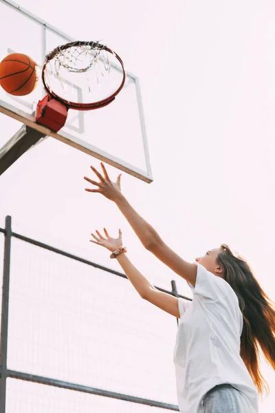 Mladá dívka hodí míč do koše a hraje basketbal. Basketbal, Sport, Hra — Stock fotografie