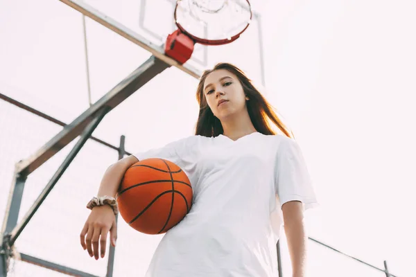 Retrato de uma jovem jogadora de basquetebol. Menina adolescente bonita jogando basquete. em sportswear jogar basquete — Fotografia de Stock