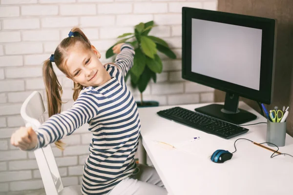 Una rubia con hermosas colas de caballo se detiene después de la tarea en el ordenador. El niño aprende de casa. Aprendizaje a distancia online. —  Fotos de Stock