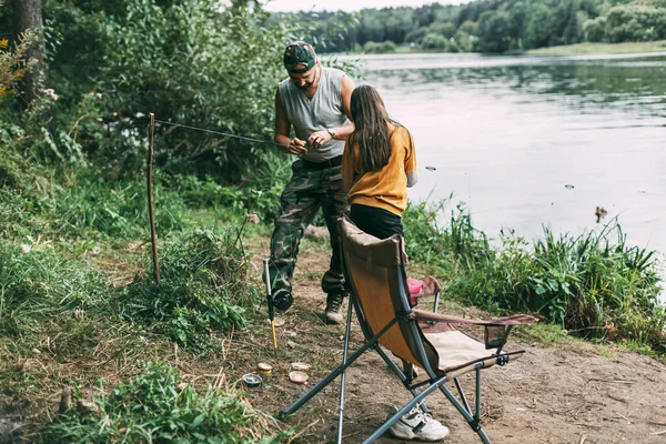 Un père apprend à sa fille adolescente à pêcher pendant les vacances en famille — Photo