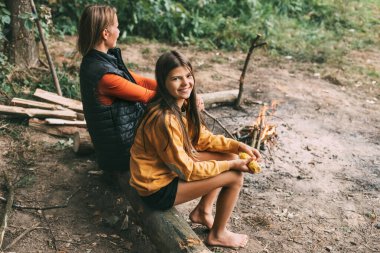 Ergen kızıyla birlikte bir anne ormanda kamp ateşinin yakınındaki bir ağaçta oturuyor ya da piknik sırasında park ediyor. Hafta sonları, tatiller, birlikte geçirdiğimiz zamanlar.