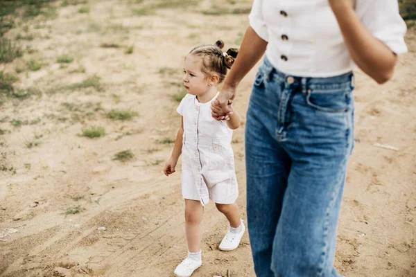 Mam en haar dochtertje lopen, houden elkaars hand vast, brengen tijd samen door. — Stockfoto