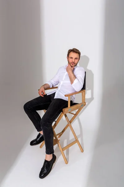 Muž Bílé Košili Tmavých Džínách Černých Botách Sedí Vysoké Židli — Stock fotografie