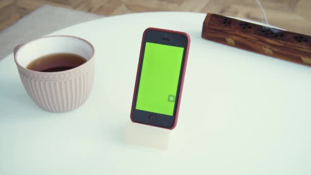 Shot zelené obrazovky šablony smartphone doma, gadget na stole. Pár čajů a indiánské kadidlo na meditaci. Rozumím. Moderní technologie a informační koncepce. — Stock video