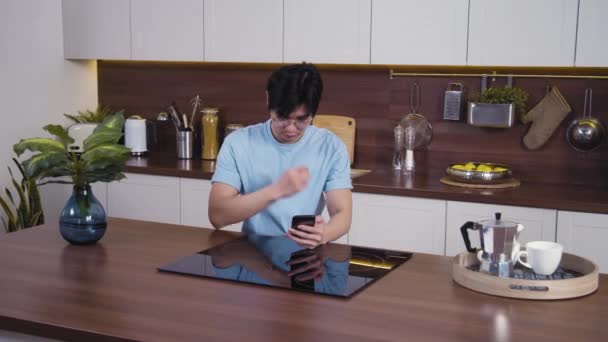 Черноволосый азиат касается волос и смотрит на селфи-камеру смартфона. Концепция здоровой прически. — стоковое видео