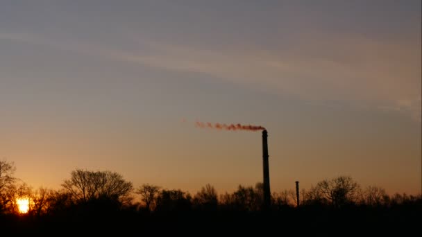 Красивая труба завода восхода солнца с дымом и движущимися облаками — стоковое видео