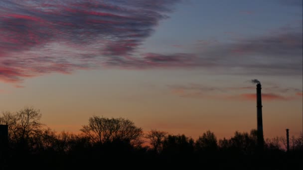 Красивая труба завода восхода солнца с дымом и движущимися облаками — стоковое видео