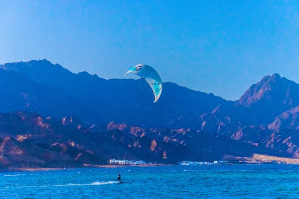 Kite surf en Dahab Egipto. Explorando el agua azul con montañas Fotos De Stock