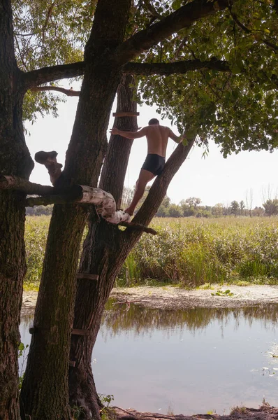 Ein Junger Mann Steht Auf Einem Baum Über Dem Fluss — Stockfoto