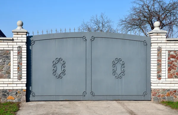 Stone fence with iron gate — Stock Photo, Image