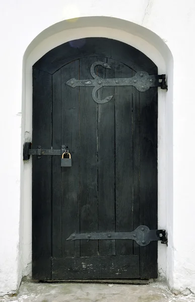 Wooden door with wrought iron ornament on it — Stock Photo, Image