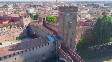 Verona, İtalya: Castelvecchio Köprüsü (Ponte di Castelvecchio) ve Castelvecchio Kalesi 'nin havadan görünüşü. Tipik İtalyan apartman çatılarıyla tarihi şehir merkezinde uçuyor. İnsansız hava aracı Adige nehrinin üzerinde uçuyor. 4K içerisindeki hava görüntüsü. 
