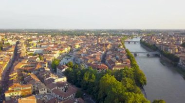 Verona tarihi şehir merkezinin panoraması, Adige nehri üzerindeki köprüler. İtalya 'da kırmızı kiremit çatılı ortaçağ binaları. 4K 'da günbatımında hava görüntüsü.