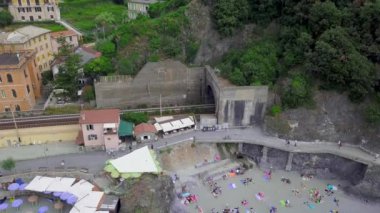 La Spezia, İtalya 'daki Cinque Terre' nin Monterosso al Mare köyünün panorama manzarası. Drone panoramik plaj manzarası, tren köyden ayrılıyor. Eski İtalyan köyünün mimarisi ve güzel bay.4K manzarası.